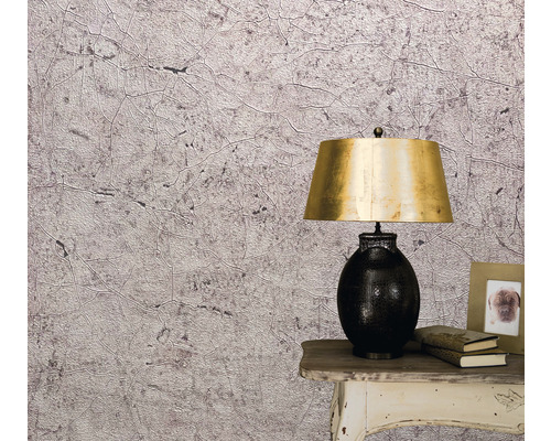 Close-up van een muur met een behang met abstract patroon, een nachtkastje en een lamp