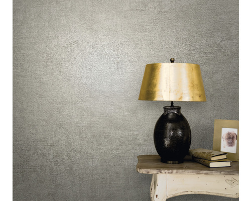 Close-up van een gestructureerd behang in een woonkamer met tafellamp en decoratie