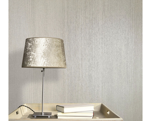 Scene met een gestructureerd behang, een lamp en boeken op een tafel