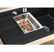 Gedetailleerd beeld van een zwarte gootsteen met roestvrijstalen inzet en cantharellen