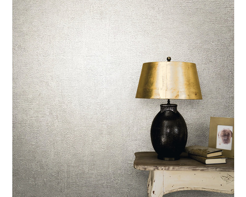 Decoratief behang met gestructureerd oppervlak naast een tafellamp.