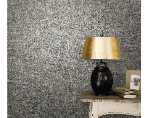 Detailopname van een patroonbehang op de muur, die naast een tafel met een lamp en decoraties is aangebracht