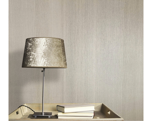 Behang met textuur naast een lamp en boeken op een tafel