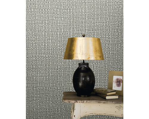 Patroont behang dat textielweefsel imiteert naast een lamp op een tafel