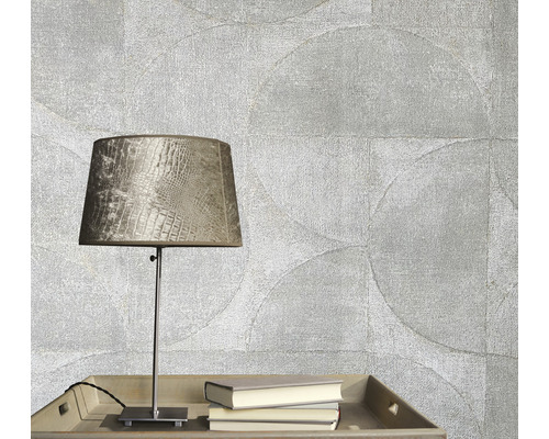 Decoratief behang met cirkelpatroon, tafellamp en boeken op een tafel