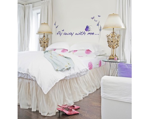 Slaapkamer met tweepersoonsbed, nachtlampjes, muursticker met vlinders en tekst