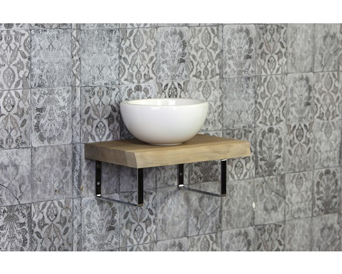 Wastafel op houten plank met metalen beugel voor een muur met patroon