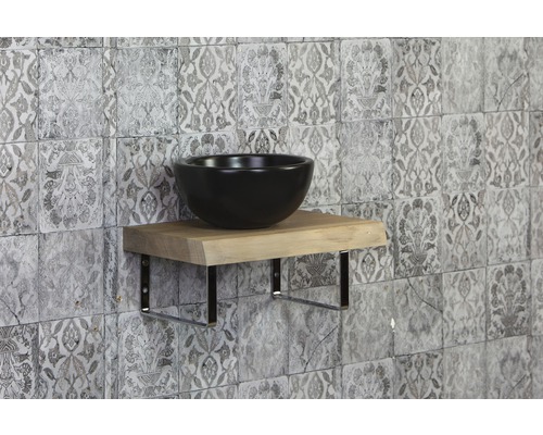 Wastafel op houten plank met metalen beugel voor een gemusterde muur