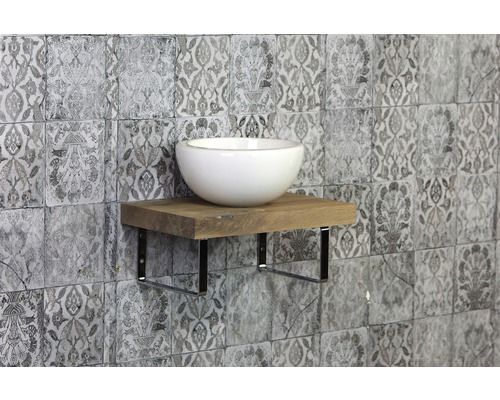 Keramische wastafel op een houten plank met metalen beugel voor een tegelwand