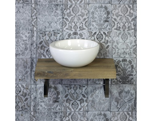 Keramische wastafel op houten console met metalen beugel voor een muur met patroon