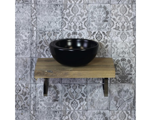 Zwarte opzetwastafel op houten plank met wandtegels op de achtergrond