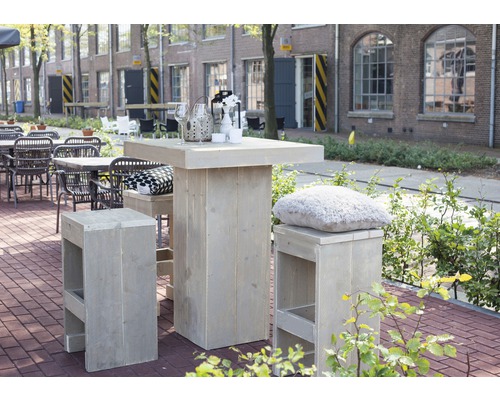 Scene met een houten statafel en barkrukken buiten.