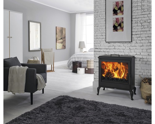 Woonkamer met kachel, fauteuil en vloerkleed