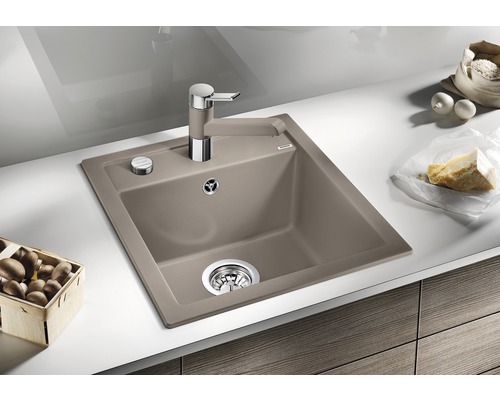 Spoelbak met afdruiprek, keukenkraan en levensmiddelen op een aanrecht