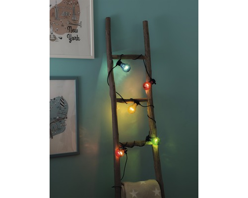 Lichtsnoer met gekleurde gloeilampen op een houten ladder