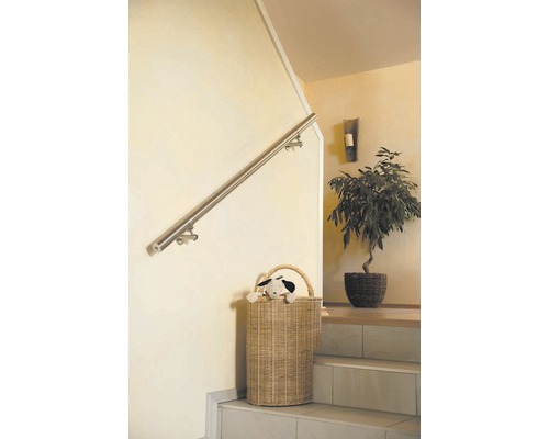 Trappenhuis met roestvrijstalen leuning en rieten mand op treden