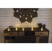 Dressoir met lades, decoratie en lichtsnoer voor een houten wand