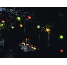 Verlichte tuintafel met decoratieve lichtslinger buitenshuis.