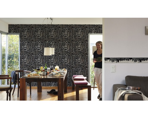 Lichte eetkamer met eettafel, stoelen, bank en behang met New York City motief.