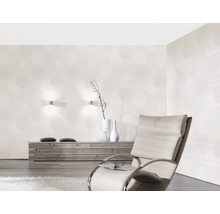 Woonkamer met patroonbehang, fauteuil en houten dressoir