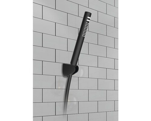 Zwarte handdouche met houder aan een betegelde muur