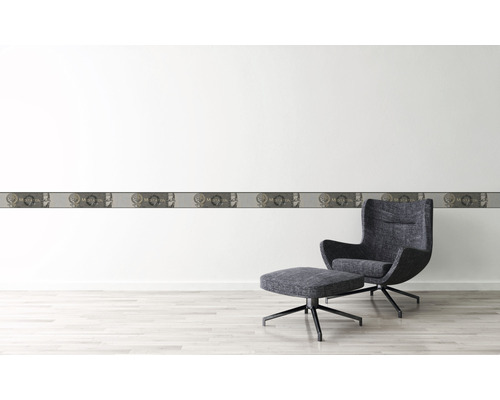 Wanddecoratie met border en fauteuil in een lichte kamer.