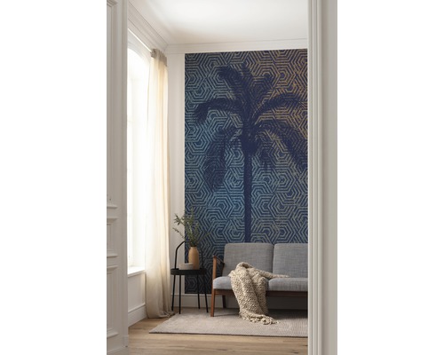 Woonkamer met fotobehang met palmmotief, bank en bijzettafel.