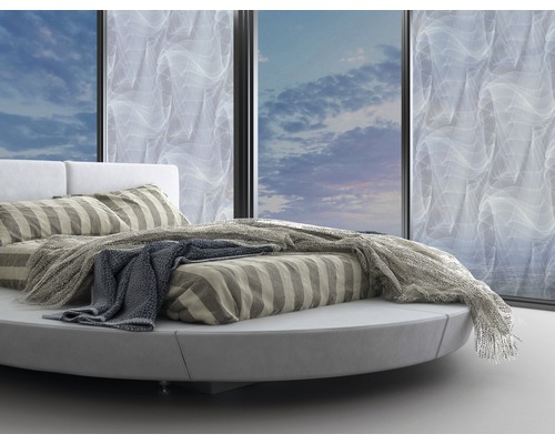Rond bed met gestreept beddengoed en sprei voor raam