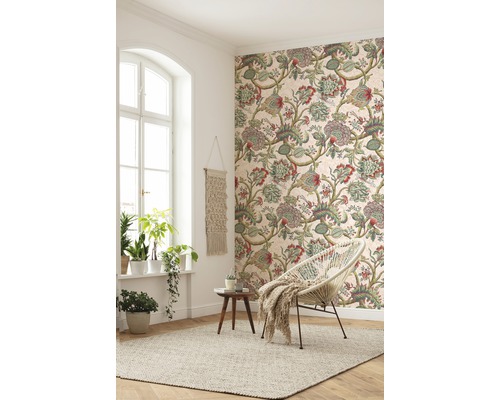 Woonkamer met patroonbehang, fauteuil en vloerkleed