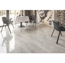 Lichte laminaatvloer in een eetkamer met tafel en stoelen.