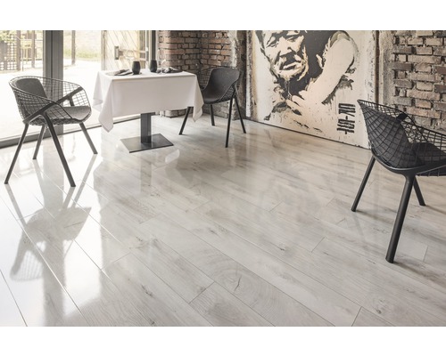 Lichte laminaatvloer in een eetkamer met tafel en stoelen.