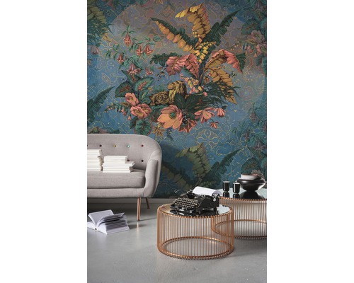 Decoratieve woonkamer met patroonbehang, bank en bijzettafels.