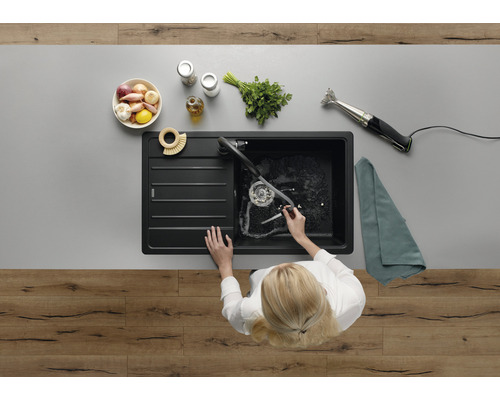 Spoelbak met afdruipvlak op een werkblad met levensmiddelen en een staafmixer, bovenaanzicht.