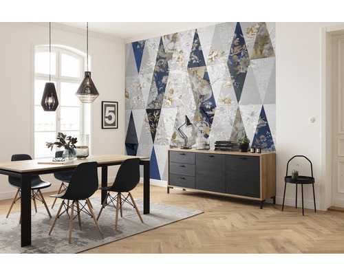 Woonkamer met eettafel, stoelen, dressoir en behang met geometrisch patroon