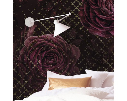 Slaapkamer met behang met rozenpatroon, bed en lamp