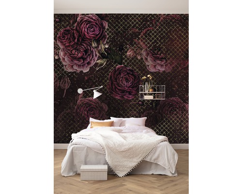 Slaapkamer met tweepersoonsbed tegen een fotobehang met bloemen rozenpatroon