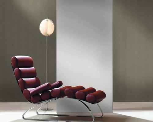 Loungebank met rolkussens op een verchroomd metalen frame en een staande lamp