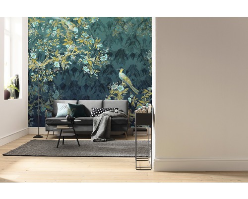 Woonkamer met bank voor een behang met patroon met plant- en vogelmotieven