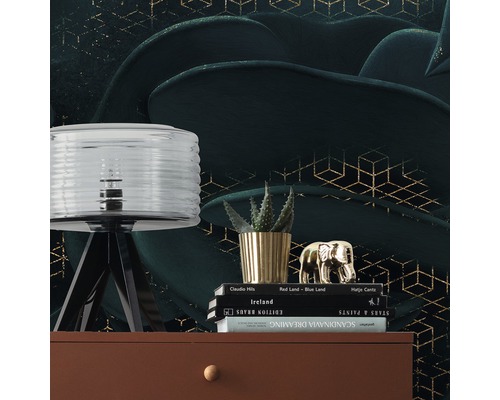 Decoratieve scène met lamp, plant, decoratief figuur en boeken op een dressoir voor een gemustereerd behang