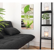 Decoratieve kunst aan de muur met steenmotief en plantmotieven in een lichte kamer met een bank en een plank