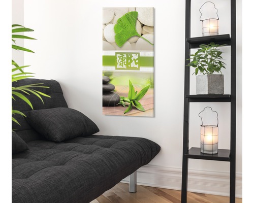 Decoratieve kunst aan de muur met steenmotief en plantmotieven in een lichte kamer met een bank en een plank