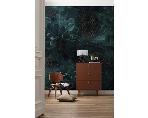 Decoratieve kamer met een wandbehang met plantenmotief, een houten commode en een houten stoel.