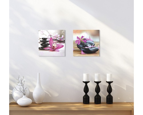 Twee wanddecoraties met steen- en bloemmotieven boven een plank met decoratie