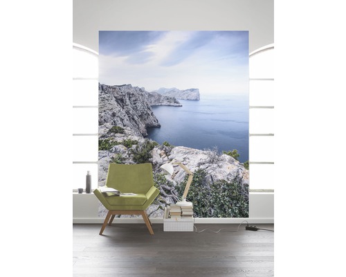 Woonkamer met fotobehang van een rotsachtig kustlandschap met uitzicht op zee