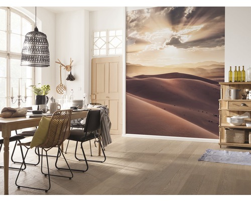 Eetkamer met eettafel, stoelen, lamp, muurschildering met duinlandschap en houten vloer