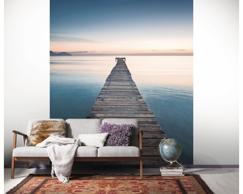 Woonkamer met fotobehang dat een houten steiger in de zee toont