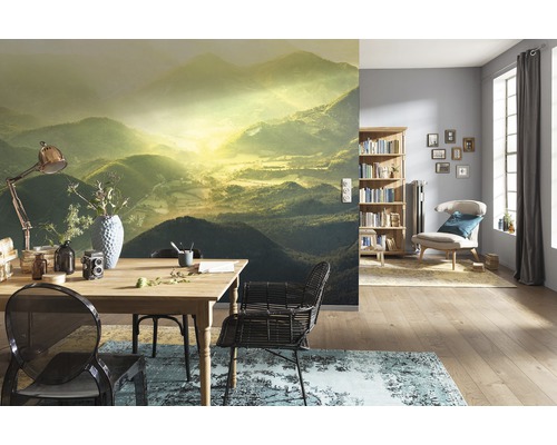 Woonkamer met fotobehang berglandschap, eettafel en boekenkast
