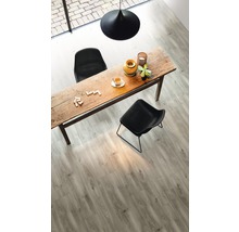 Interieurfoto van een woonkamer met houten tafel, stoelen en laminaatvloer.
