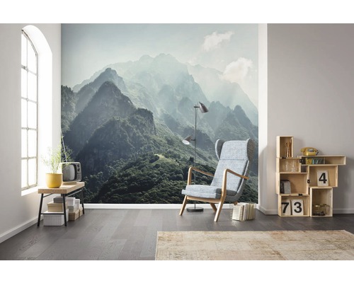 Woonkamer met behang met bergmotief, fauteuil en rekken