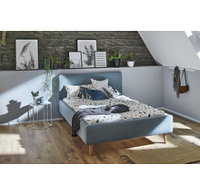 Slaapkamer met blauw bed, nachtkastje en decoraties